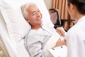 DLBCL Diagnosis and First Line Treatment: An elderly patient smiles at his Doctor during examination
