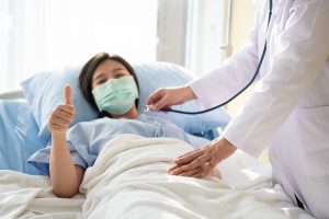 DLBCL Diagnosis and First Line Treatment: Lady giving a thumbs up while the Doctor examines her